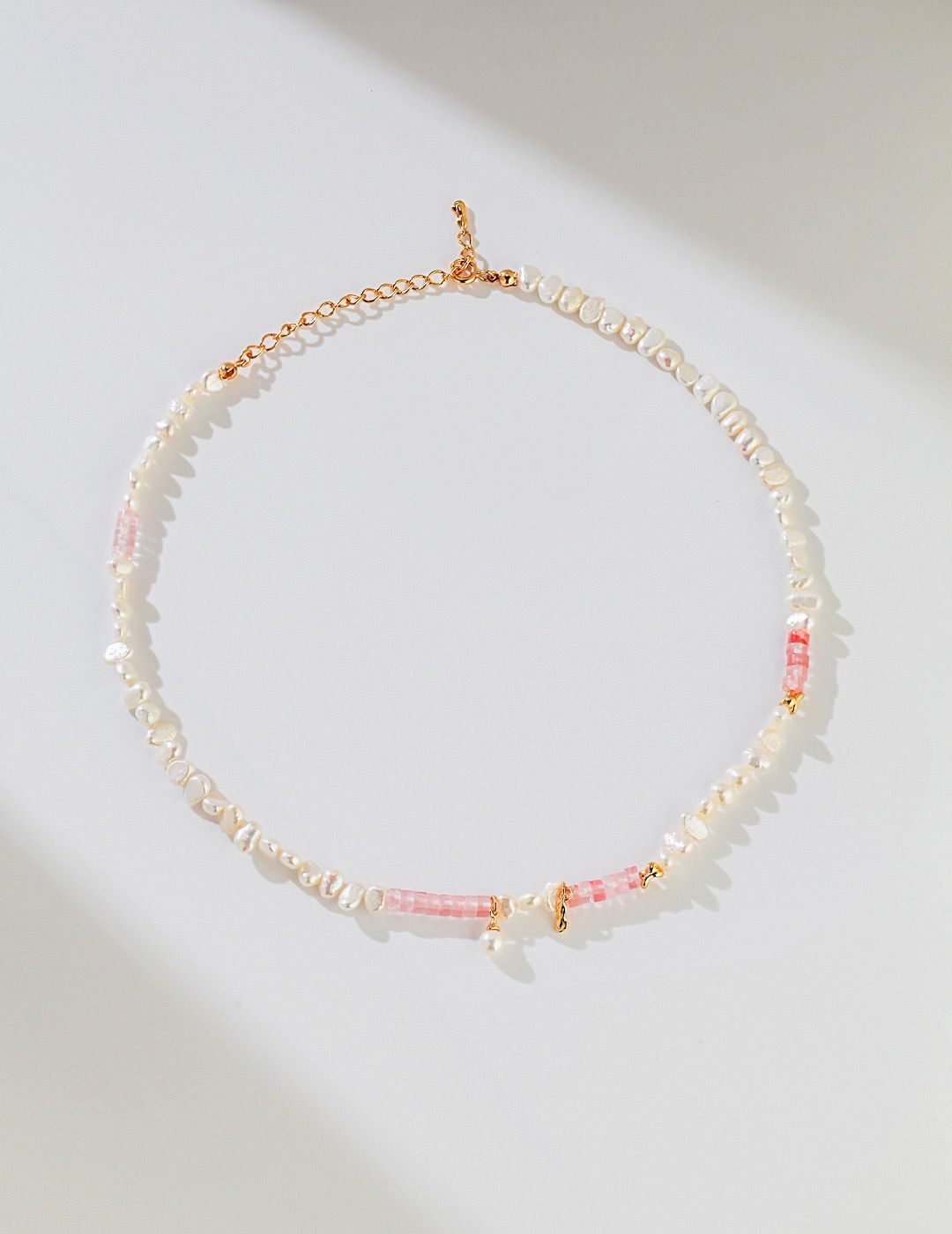Discover our Golden Blush Pearl Necklace, with freshwater pearls and pink accents on a gold chain. Sophisticated and versatile, this piece adds elegance to any outfit.