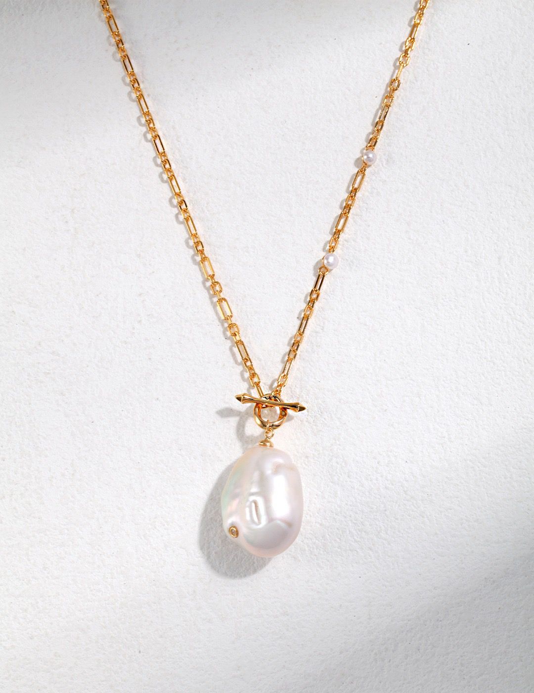 Add classic elegance to any outfit with our Timeless Baroque Pearl Pendant Necklace. Featuring a lustrous freshwater pearl with an irregular shape, suspended on a delicate metal chain. Perfect for any occasion, this necklace is sure to become a treasured addition to your jewelry collection
