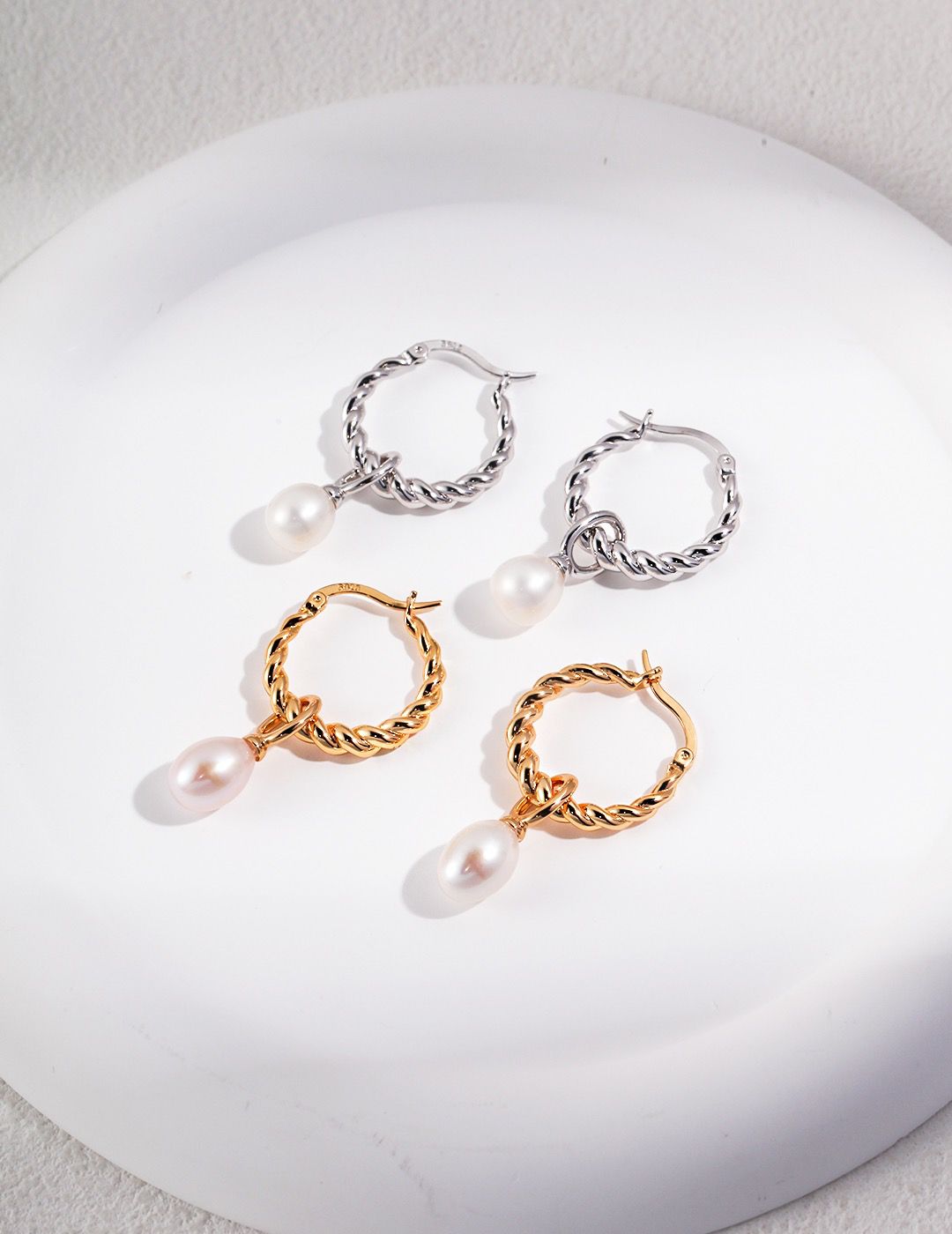 A close-up photo of Pearl Hoop Earrings on a white background.